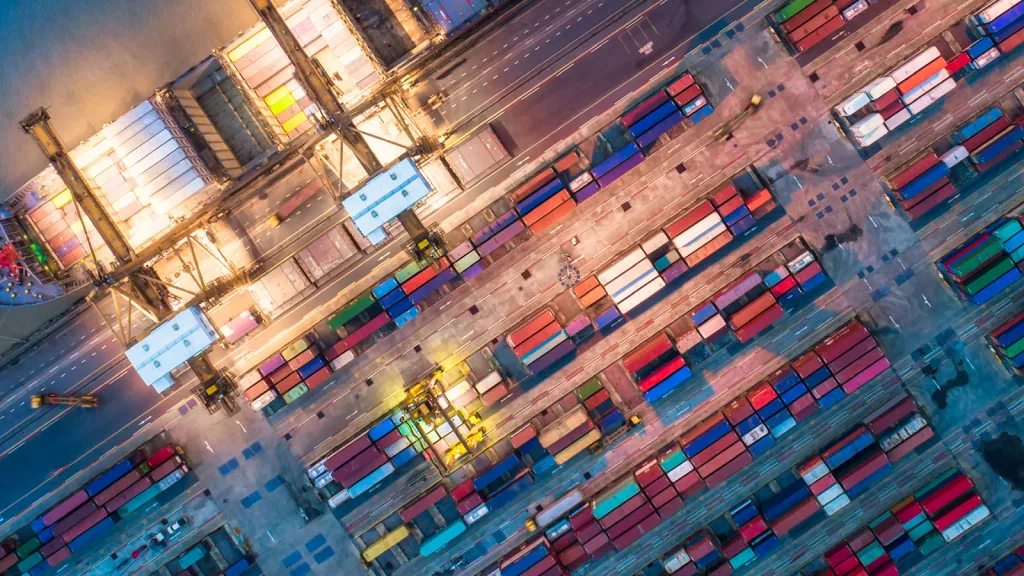 Bird's-eye view of a container terminal, showcasing rows of containers and active loading equipment